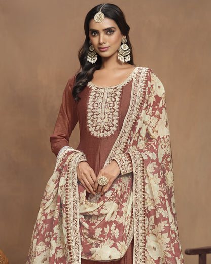 Woman wearing a traditional outfit with intricate embroidery on a brown background
