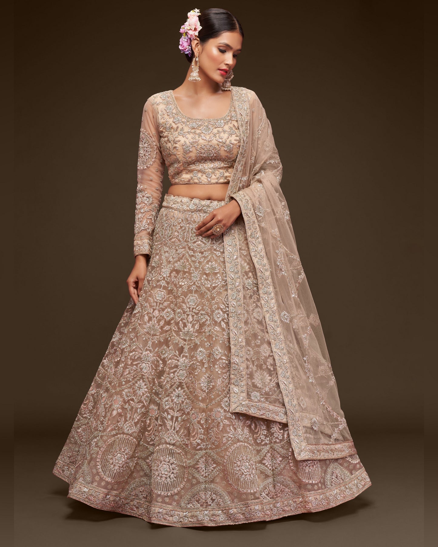 Woman wearing a traditional embroidered outfit with a plain background