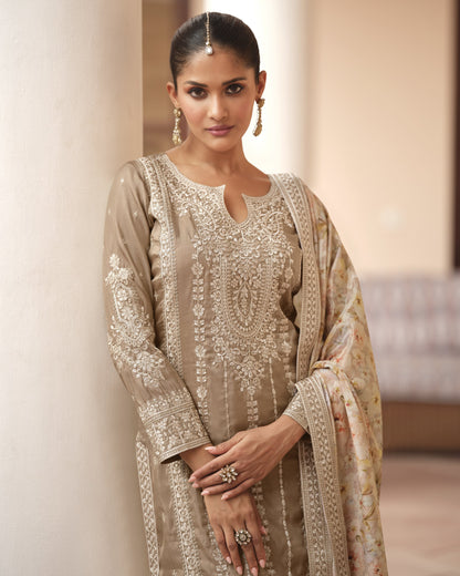 Woman wearing a traditional embroidered outfit with a plain background