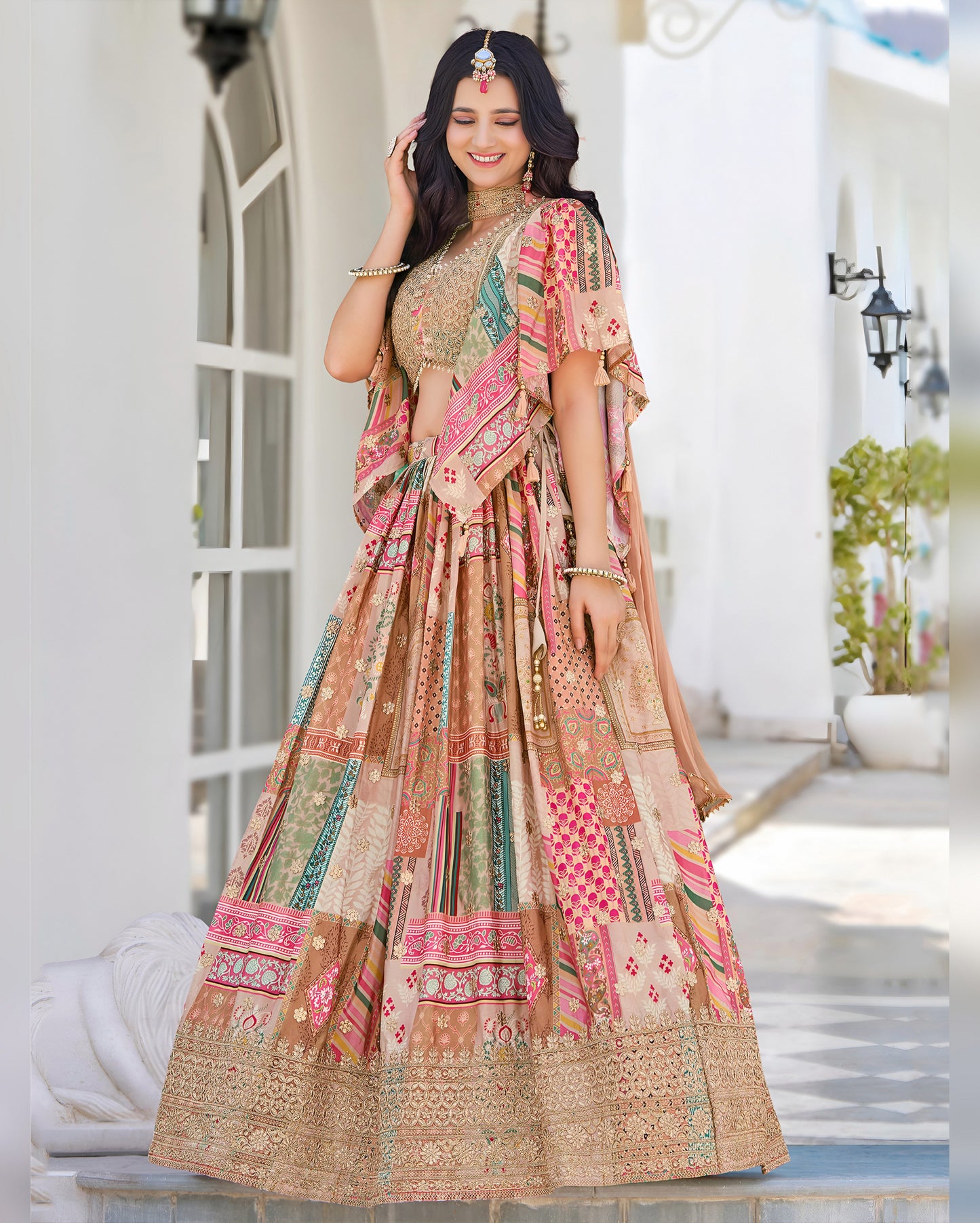 Woman wearing a colorful traditional outfit with a patterned dress and dupatta in an outdoor setting.