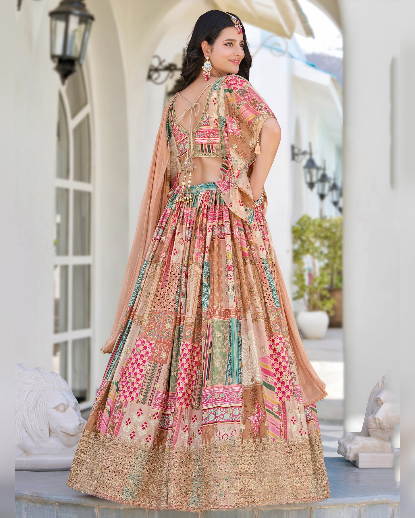 Woman in a traditional embroidered dress standing in an elegant outdoor setting.