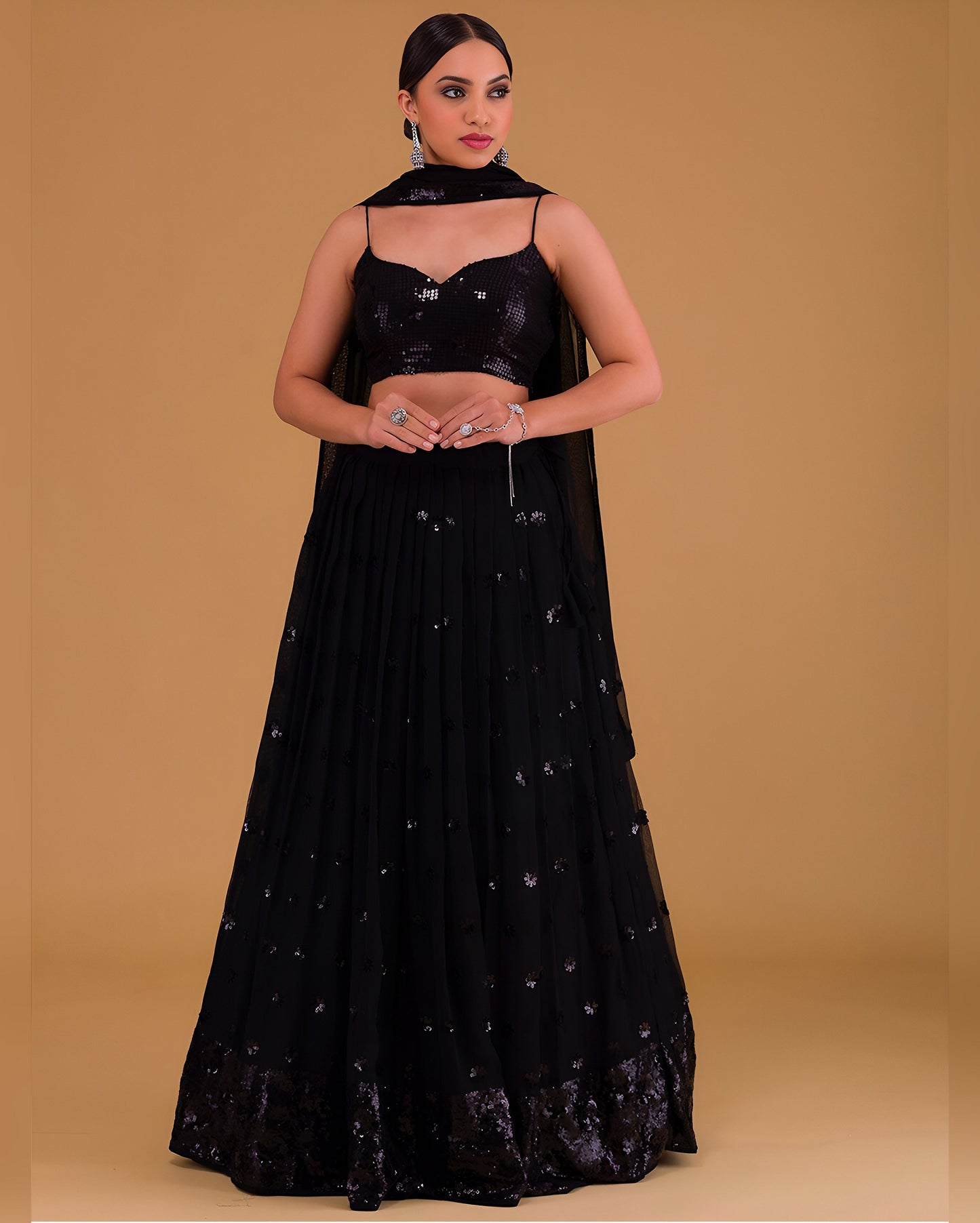 Woman wearing a black embroidered outfit on a beige background