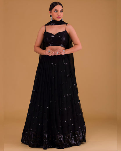 Woman wearing a black embroidered outfit on a beige background