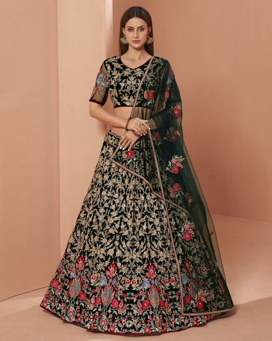 Woman wearing a black floral embroidered lehenga on a beige background