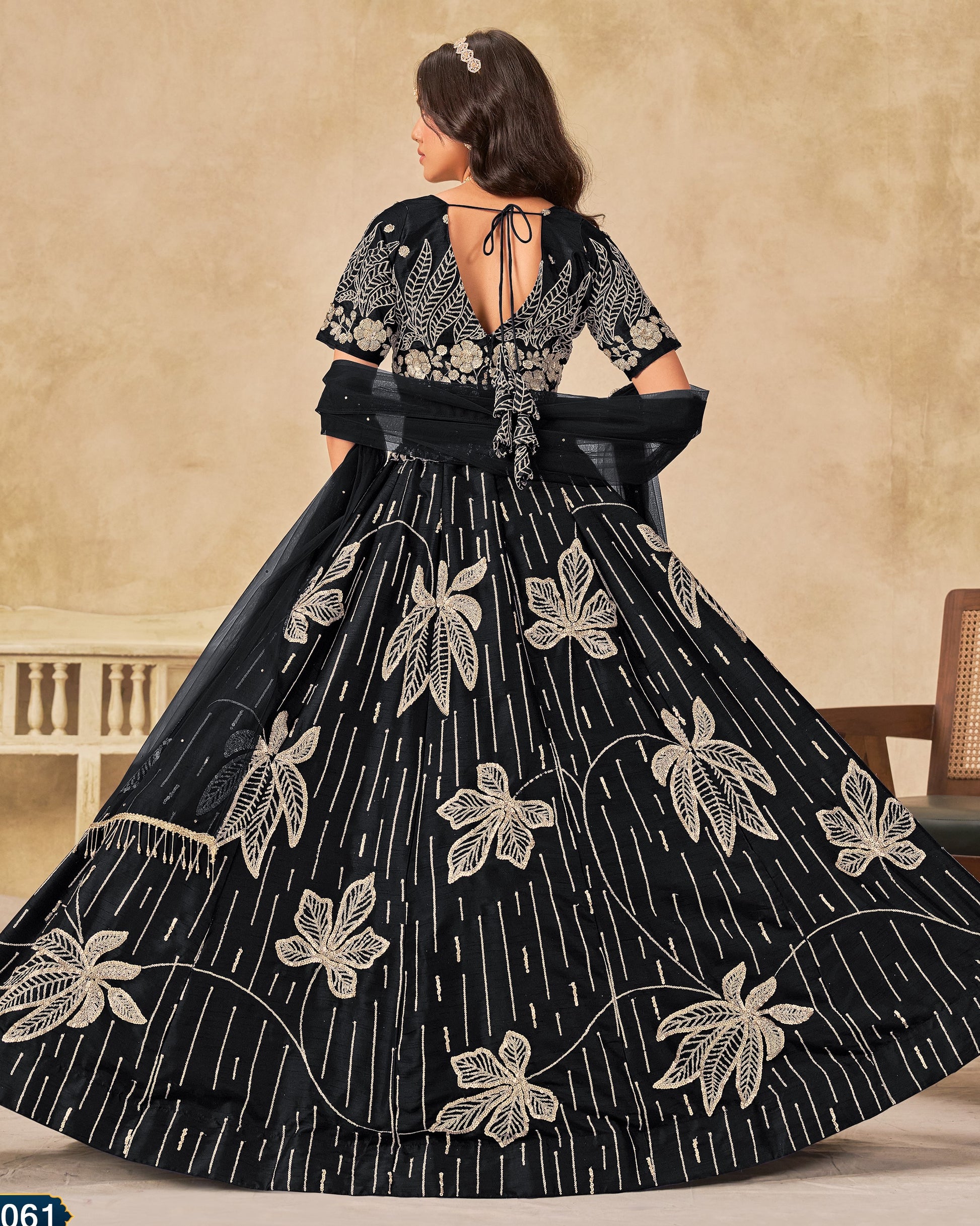 Black embroidered dress with floral patterns on a beige background