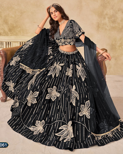 Woman wearing a black and gold embroidered lehenga sitting on a couch.