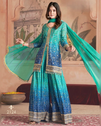Woman in a blue and green traditional outfit with a decorative background