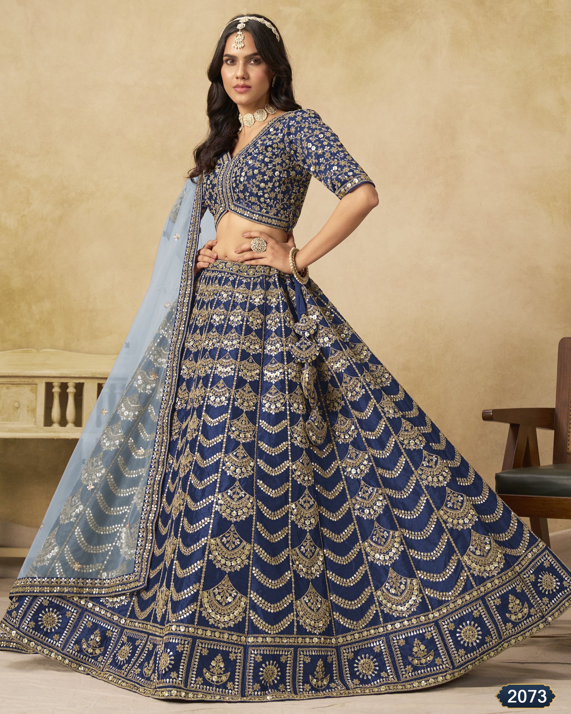Woman wearing a blue embroidered traditional outfit with a beige background