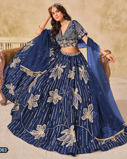 Woman wearing a blue embroidered lehenga with a beige background