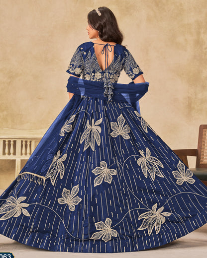 Woman wearing a blue embroidered dress with a beige background