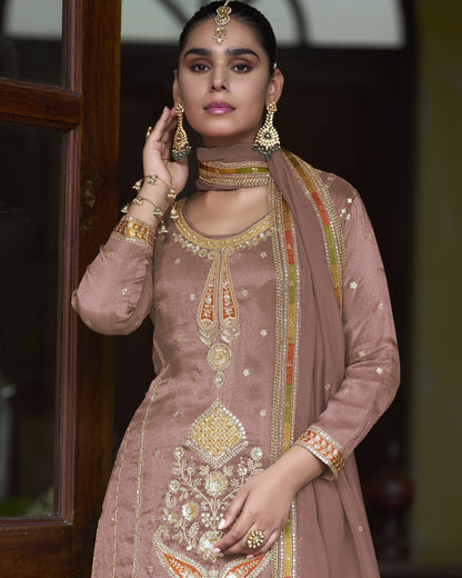 Woman wearing a traditional embroidered outfit with jewelry indoors.