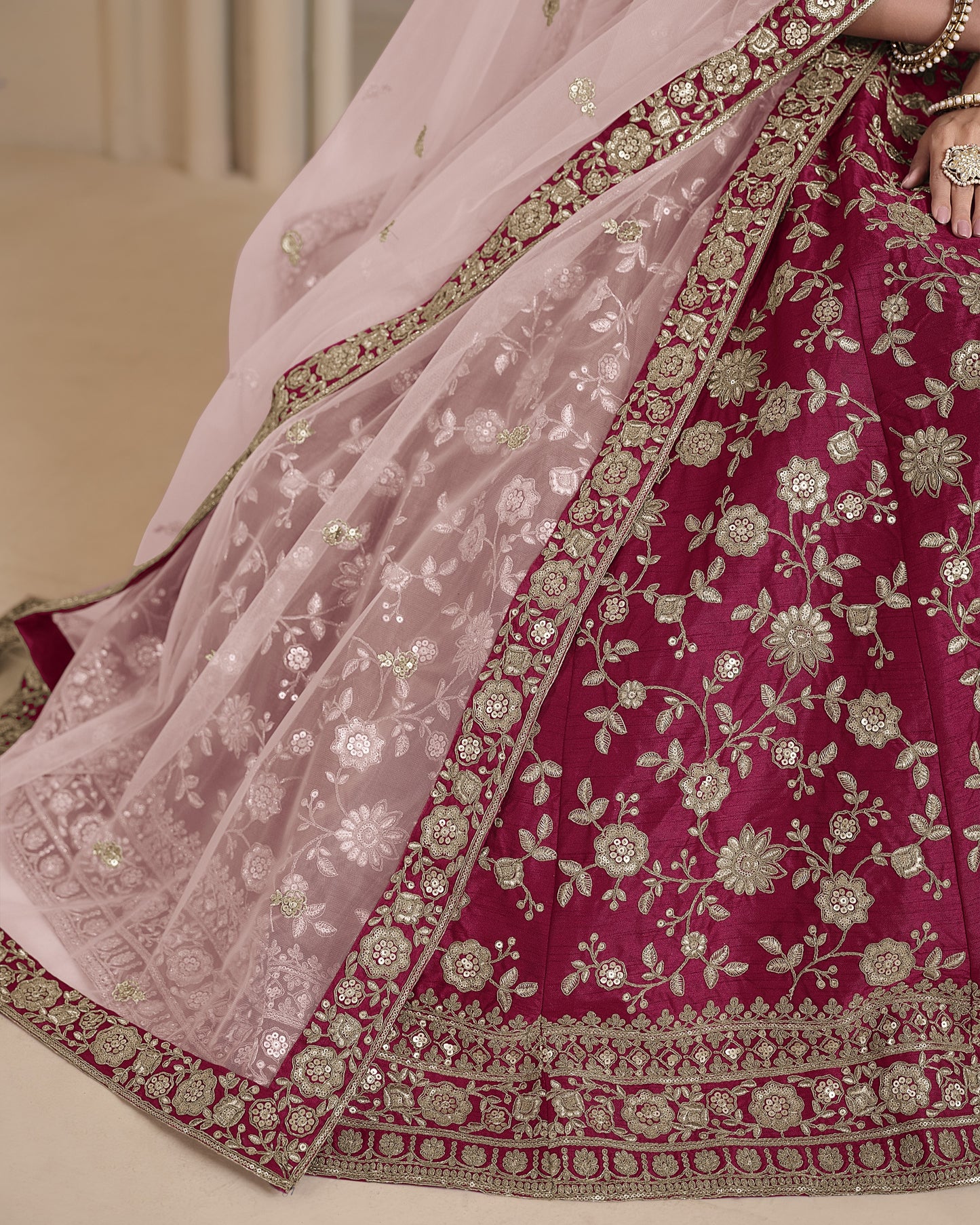 Traditional embroidered saree with pink and red colors on a neutral background