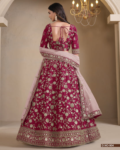 Pink and red embroidered traditional outfit with a chandelier in the background