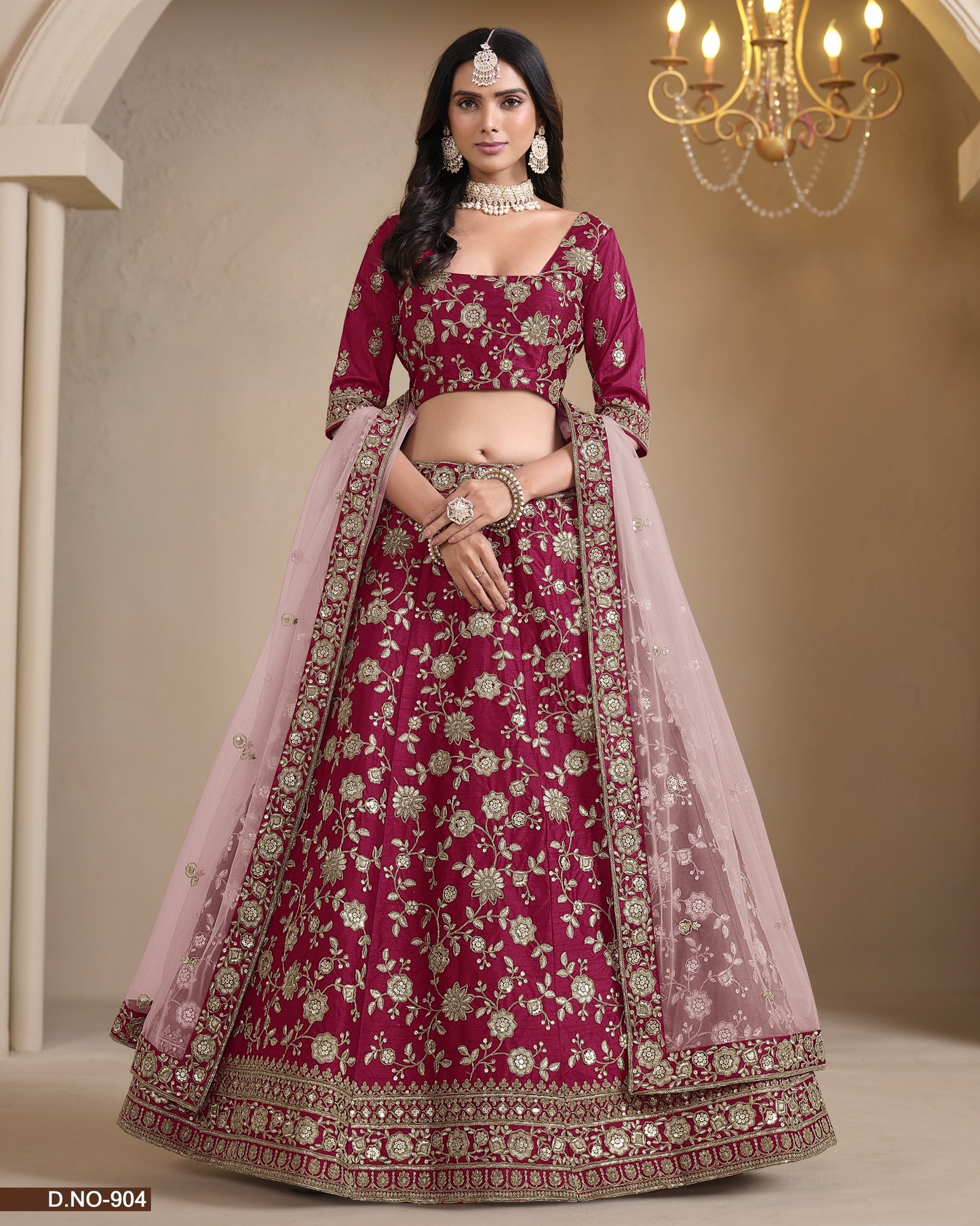 Traditional pink embroidered lehenga with a chandelier in the background