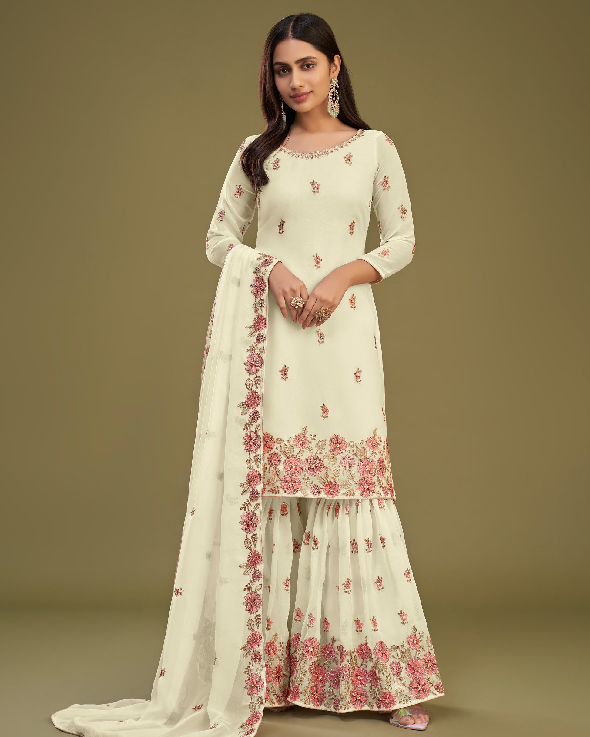 Woman wearing a white floral embroidered outfit on a beige background