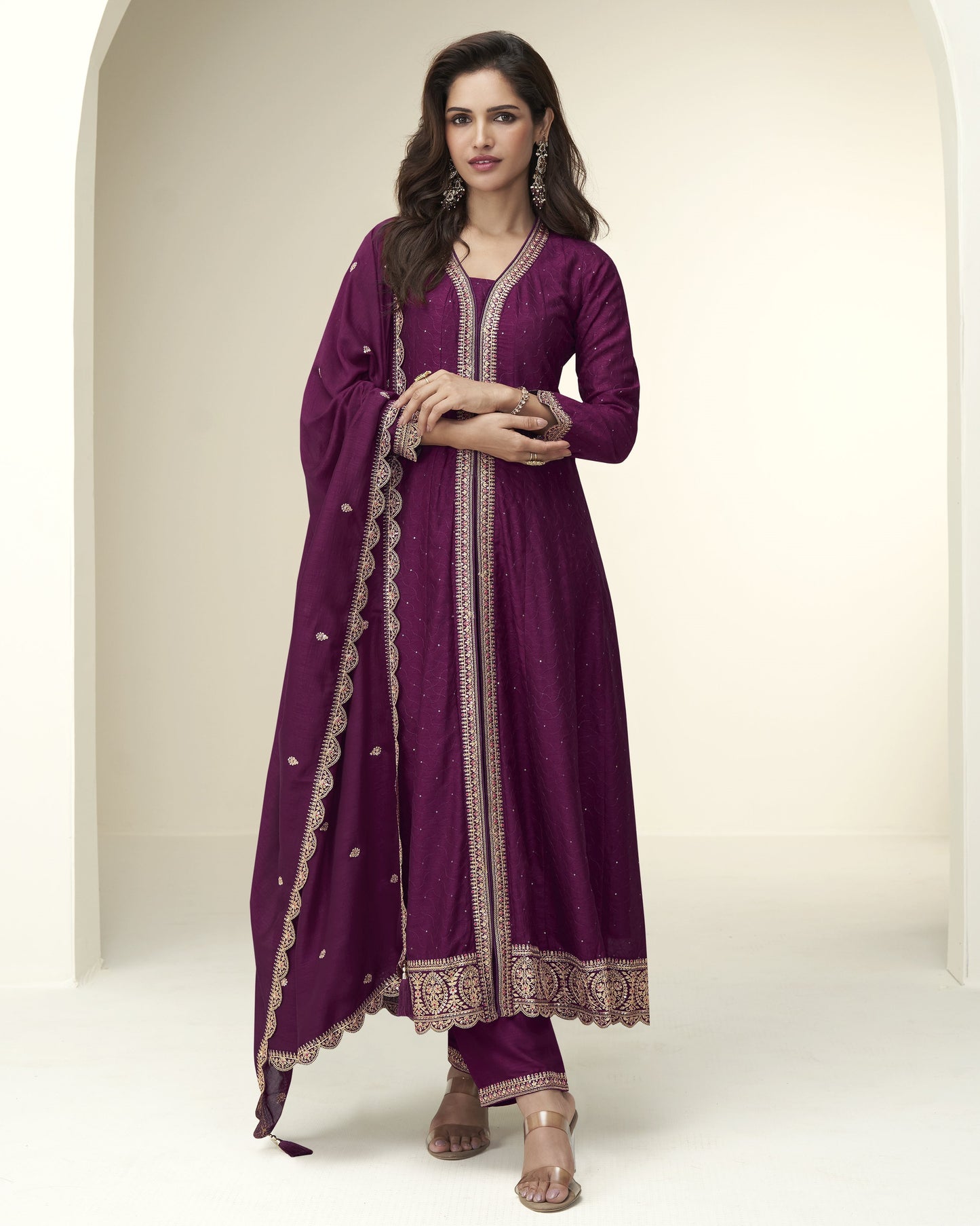 Woman wearing a purple traditional outfit with intricate designs on a white background