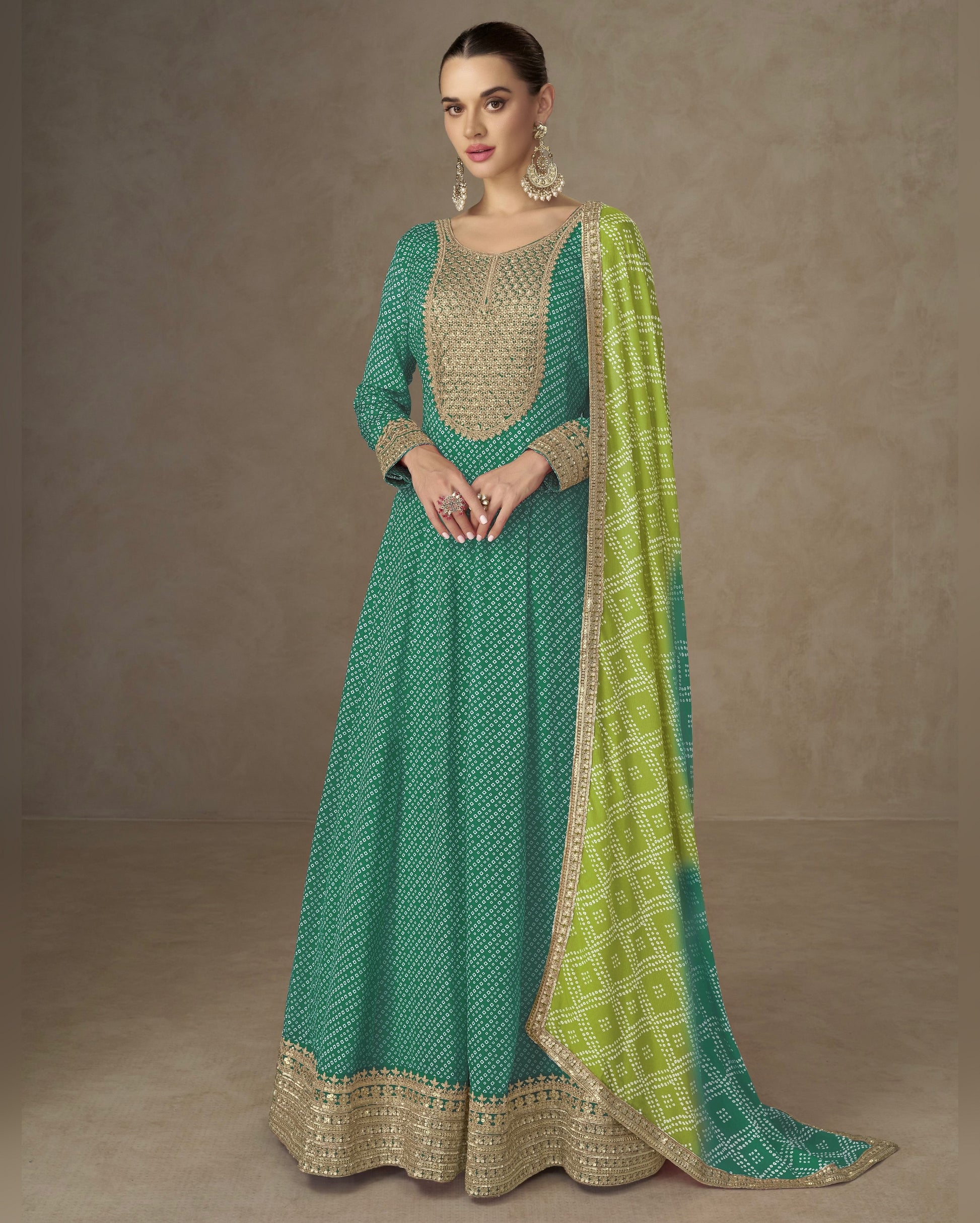 Woman wearing a green and beige traditional outfit with a matching dupatta on a plain background