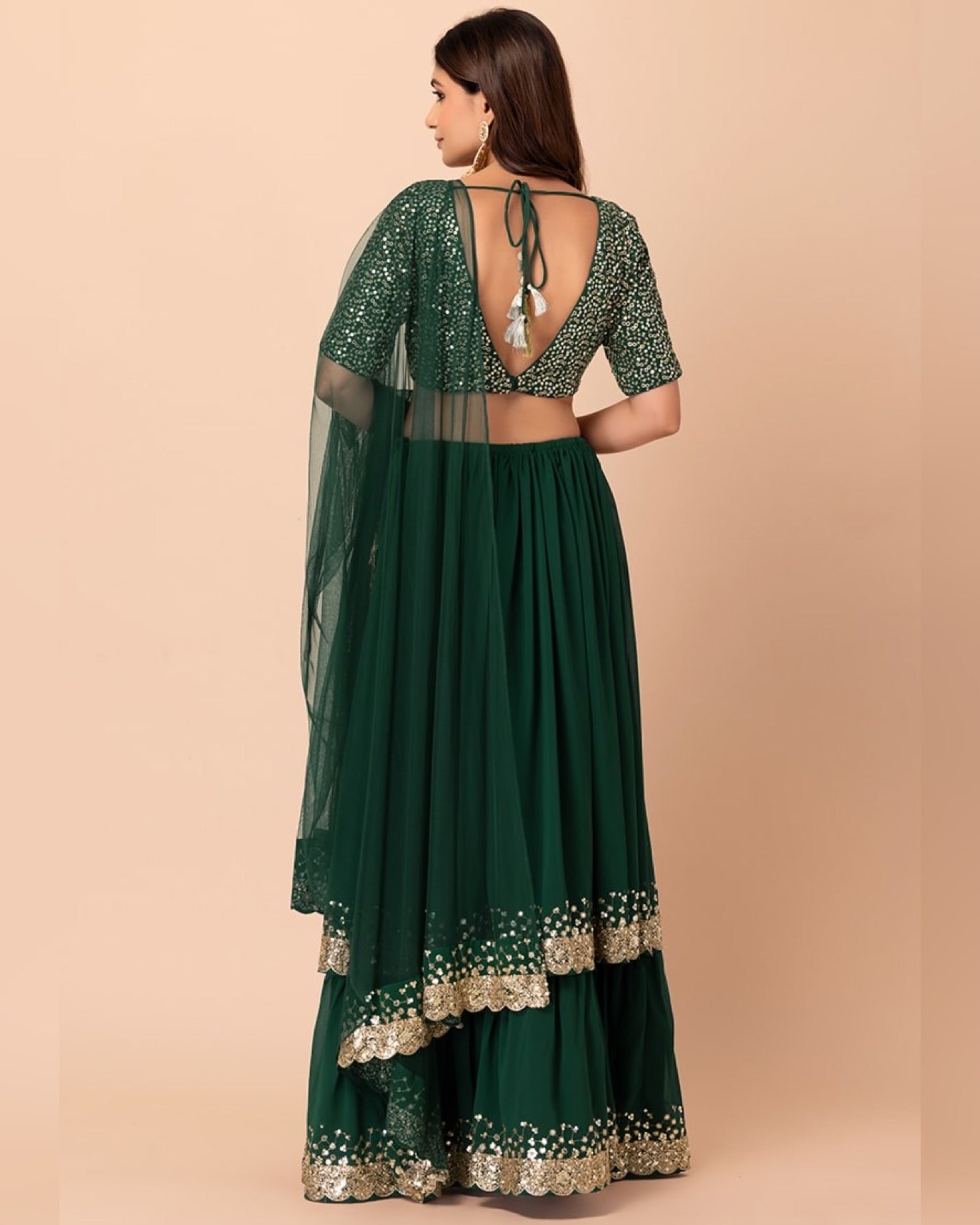 Green traditional outfit with gold details on a beige background