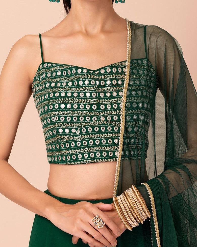 Green embroidered blouse with a sheer green dupatta on a beige background