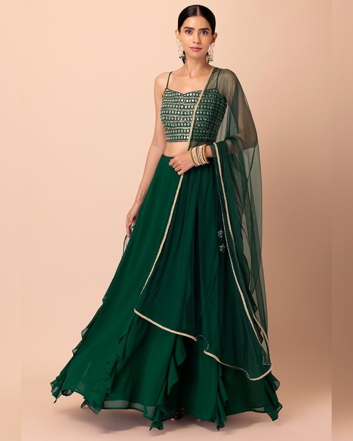 Green traditional outfit with a matching dupatta on a beige background