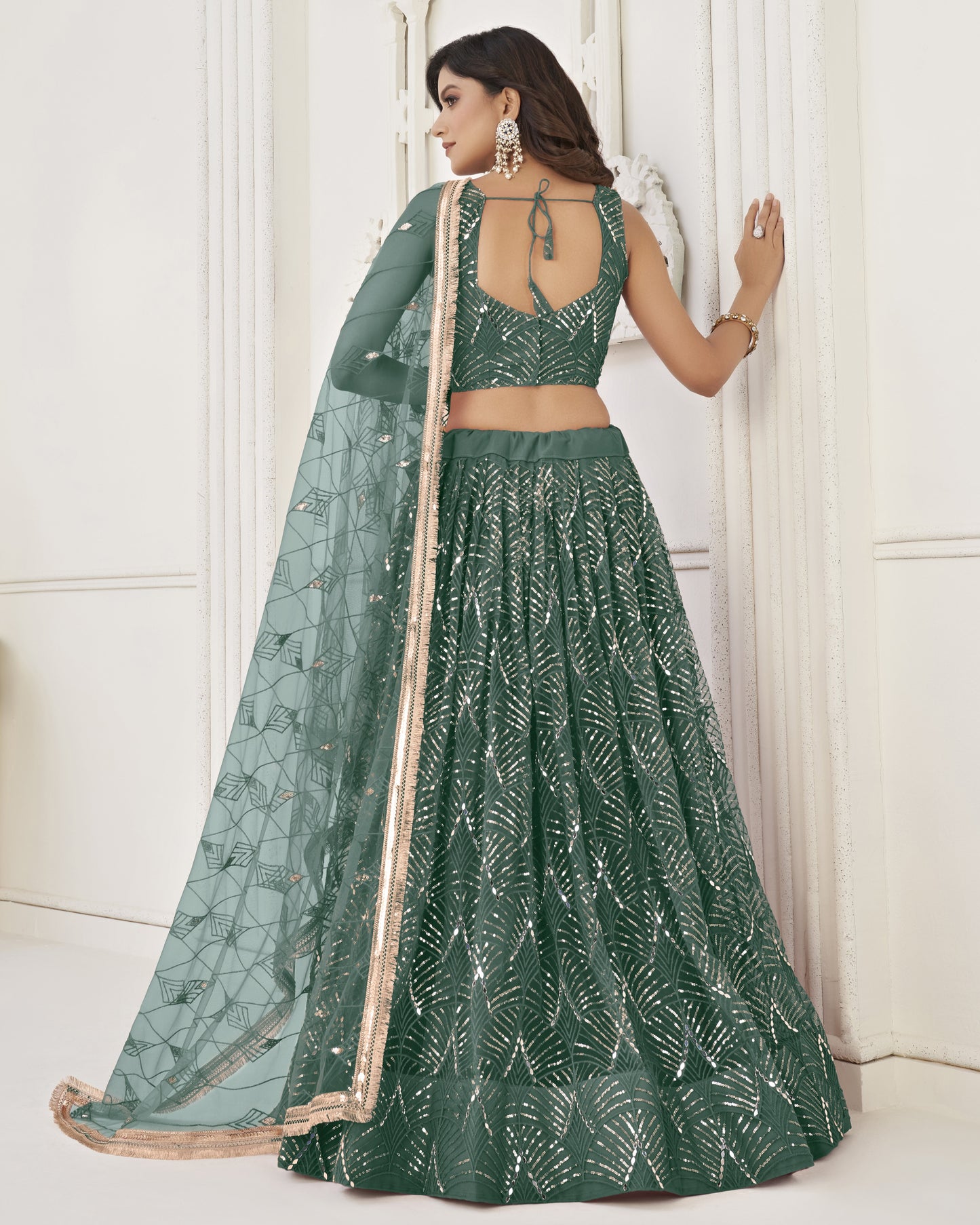 Woman wearing a green saree with a white background