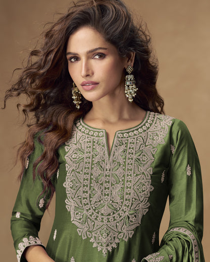 Woman wearing a green embroidered traditional outfit with a brown background