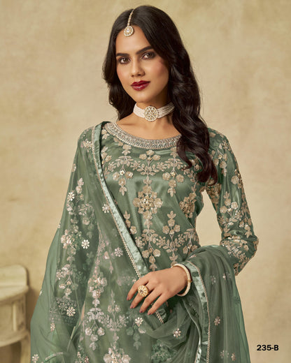 Woman wearing a green embroidered traditional outfit with a beige background