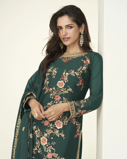 Woman wearing a green embroidered dress against a white background