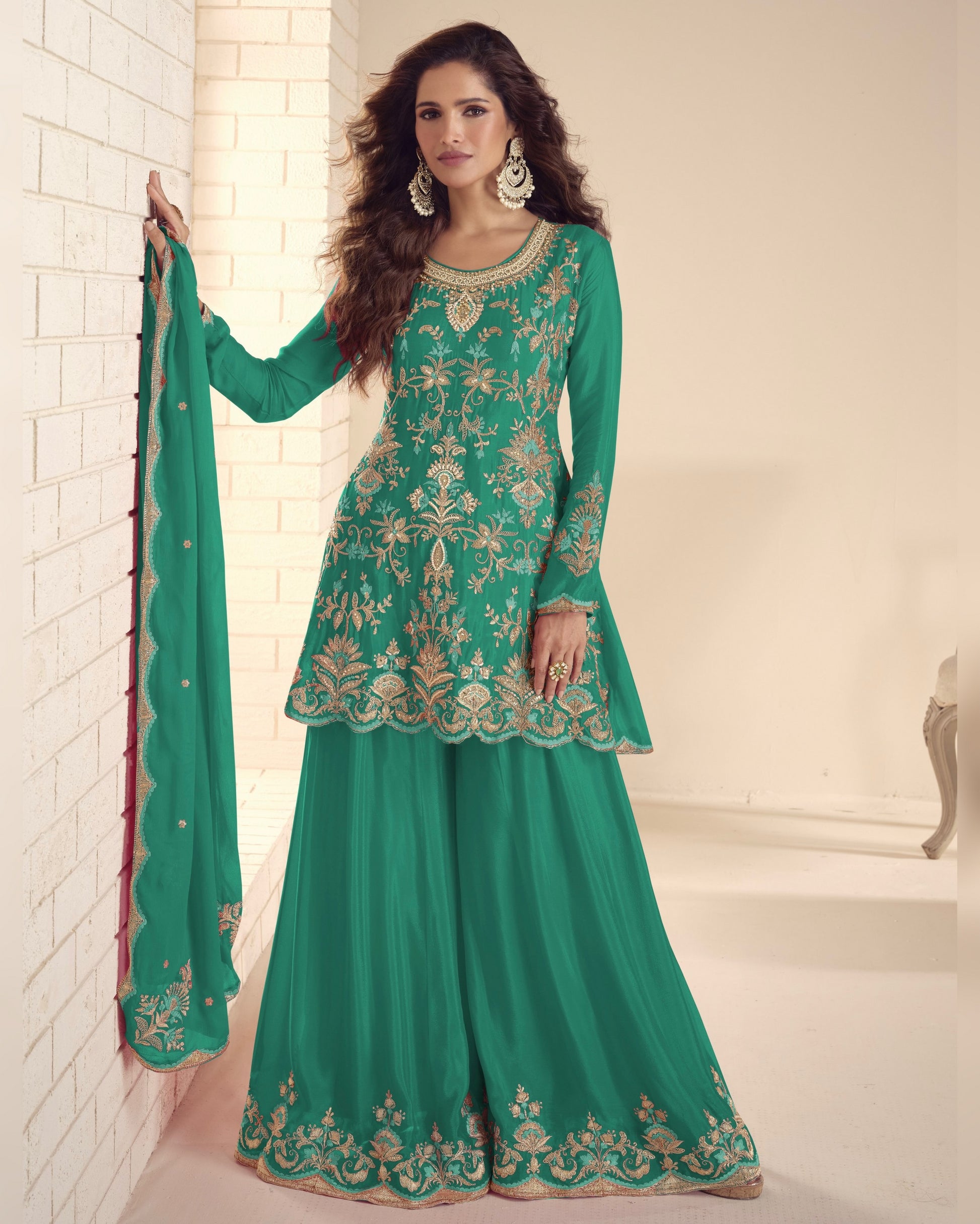 Woman wearing a green embroidered traditional outfit with a white background