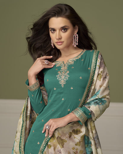 Woman wearing a green embroidered traditional outfit with a floral patterned dupatta against a neutral background