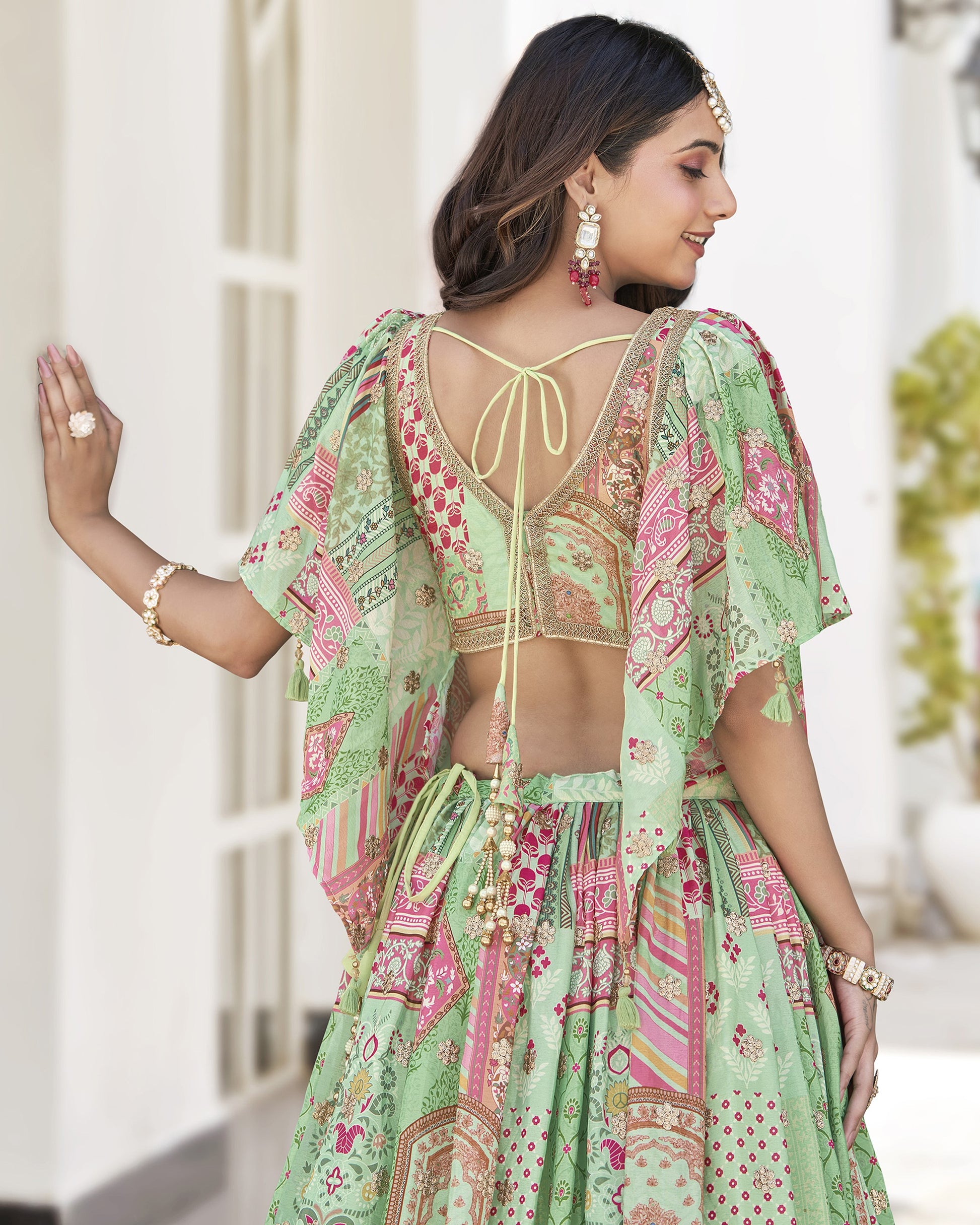 Woman wearing a green and pink patterned outfit with a blurred background