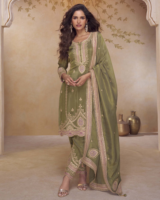 Woman wearing a green embroidered saree in an elegant setting