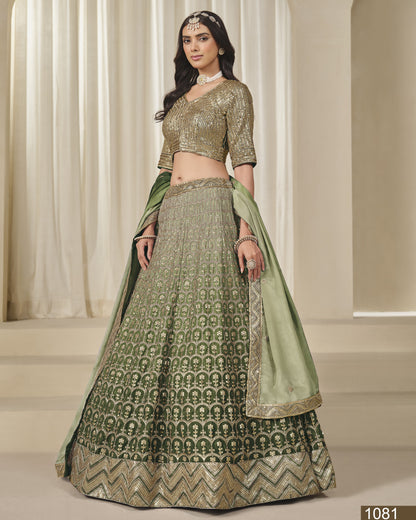 Woman wearing a green and gold traditional outfit with a matching dupatta in a neutral setting.