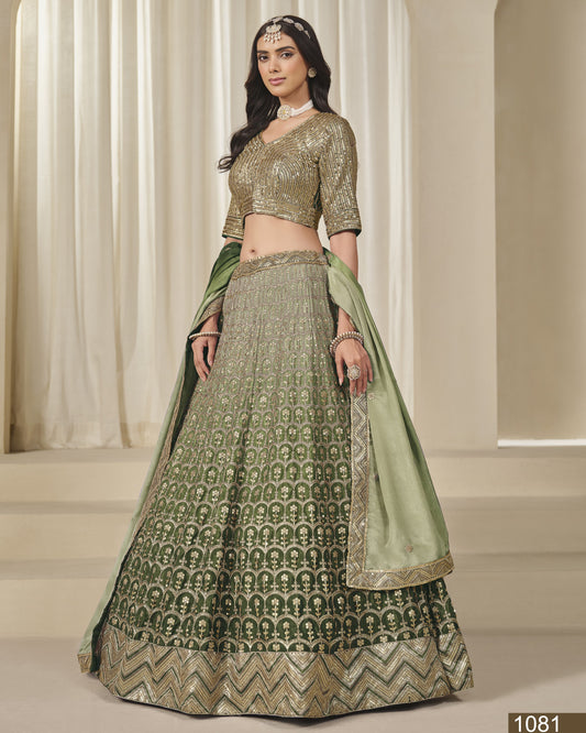 Woman wearing a green and gold traditional outfit with a matching dupatta in a neutral setting.