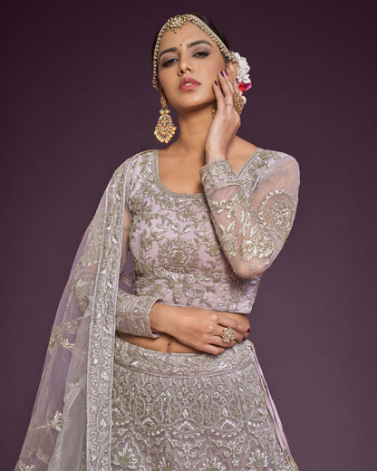 Woman in traditional silver embroidered outfit with jewelry against a dark background