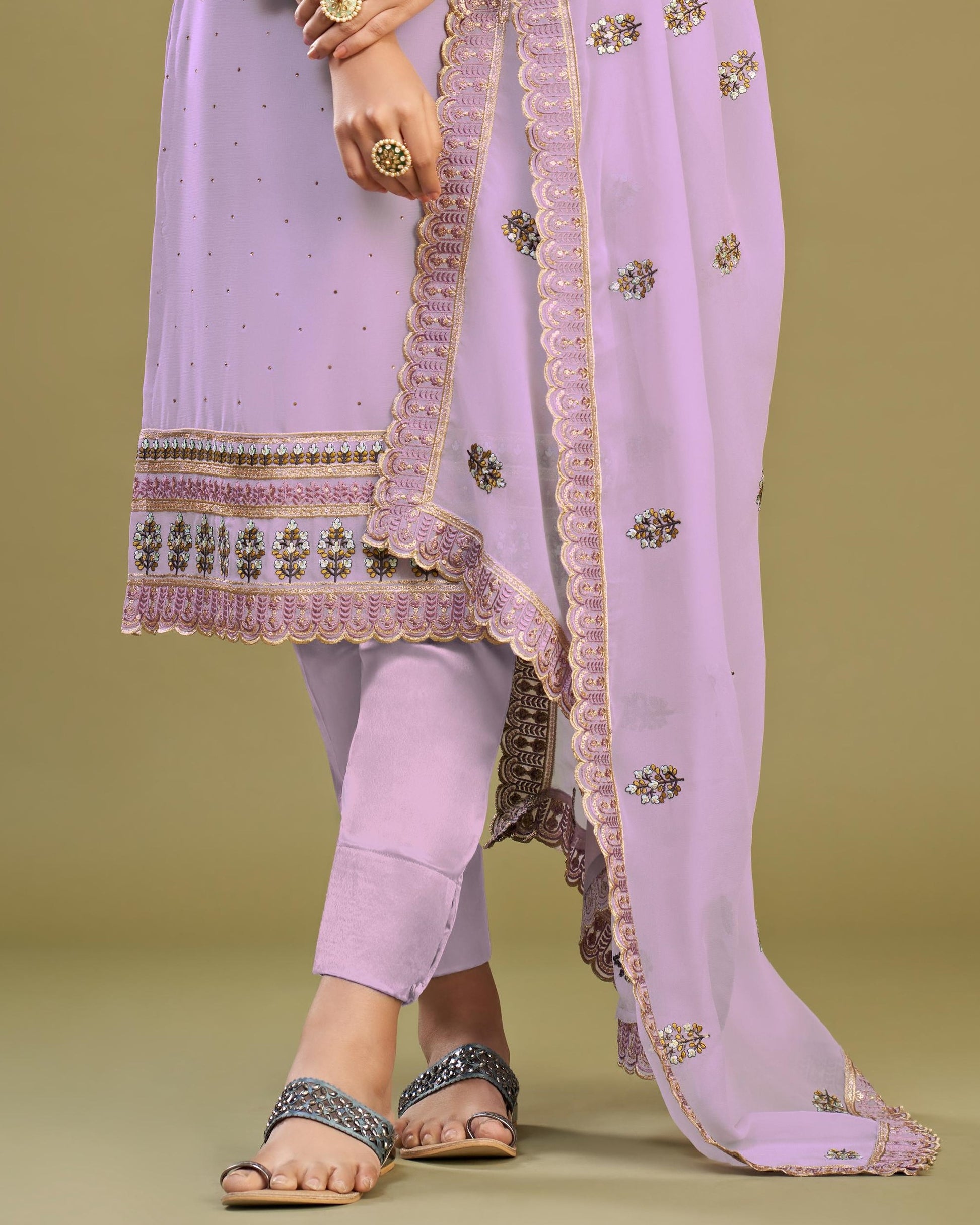 Lavender traditional outfit with embroidered dupatta on a green background