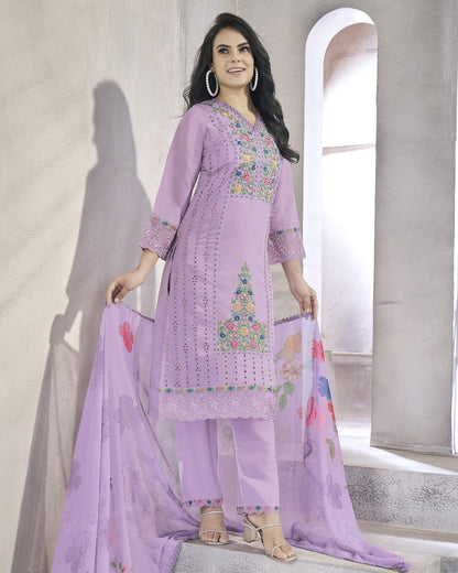 Woman wearing a light purple embroidered outfit with a floral dupatta in a neutral setting.