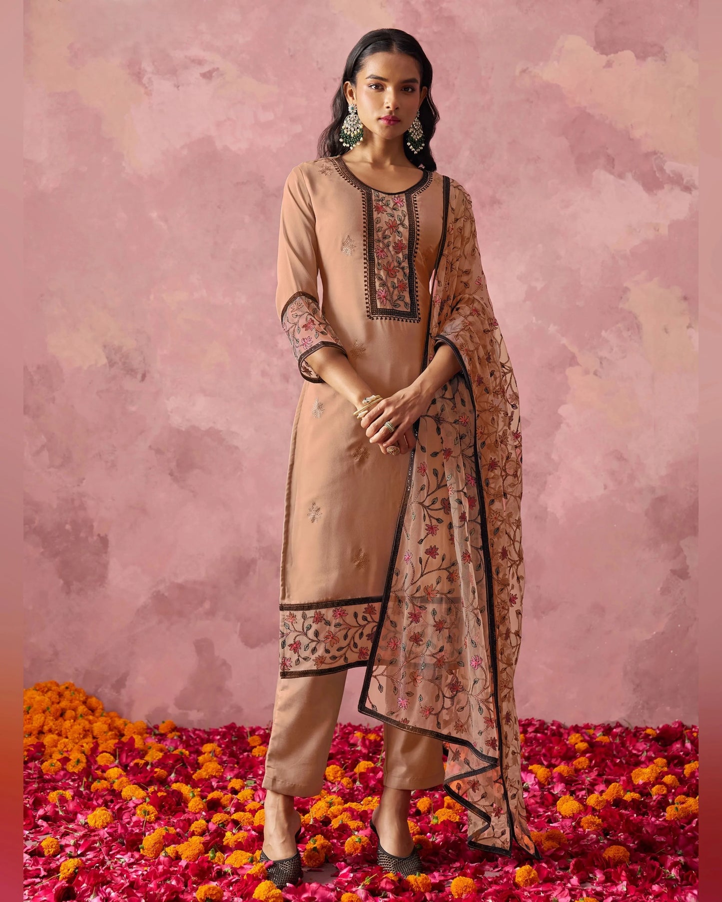 Woman in a traditional outfit with floral patterns on a pink floral background