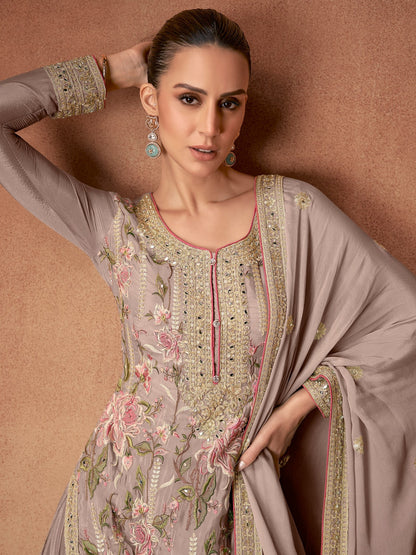 Woman wearing a traditional embroidered outfit against a beige background