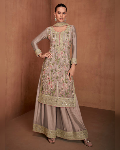 Woman wearing a traditional embroidered outfit on a brown background