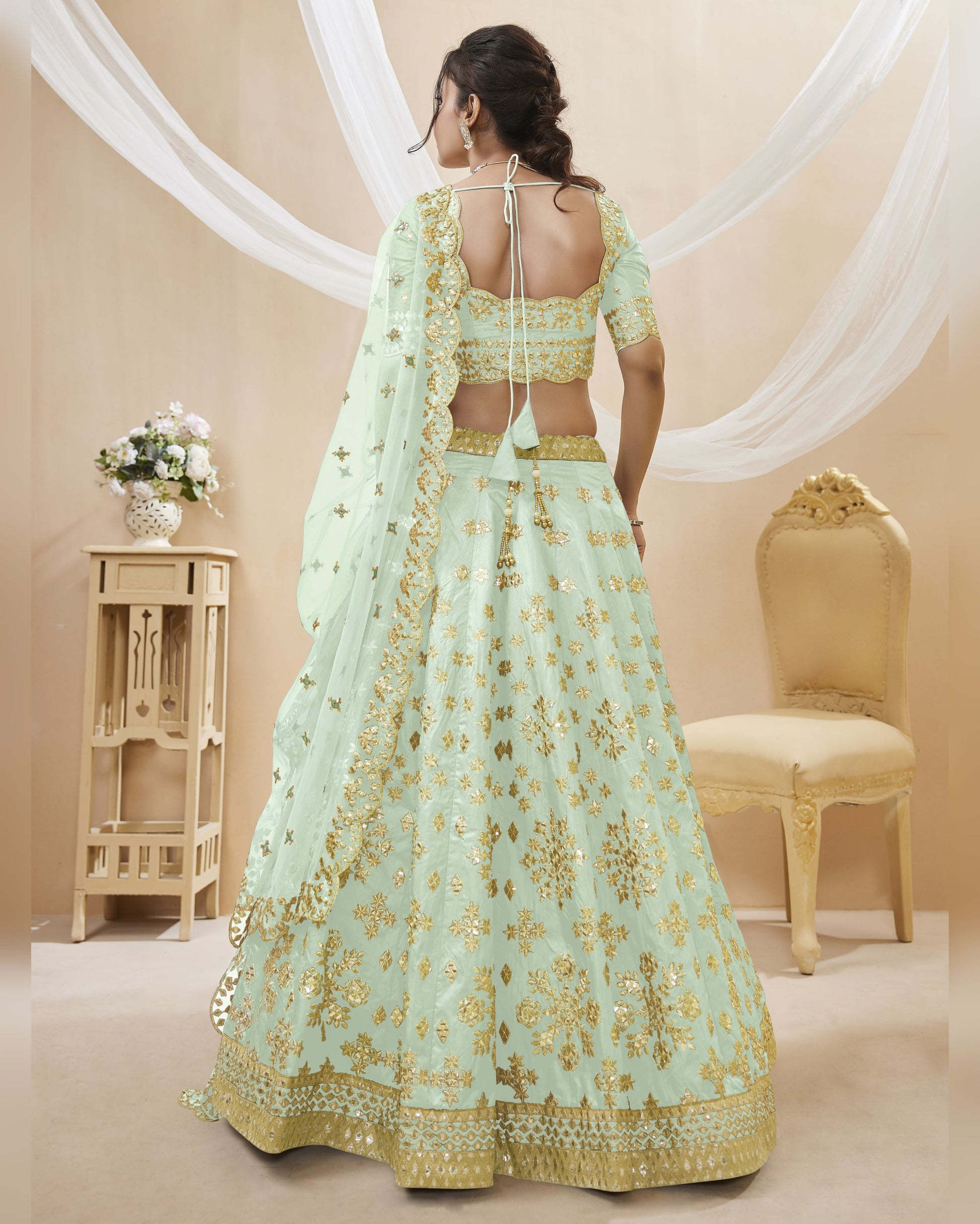 Light blue and gold embroidered traditional outfit with a beige background