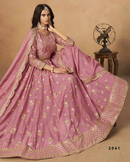 Woman in a pink traditional outfit with gold embroidery on a beige background