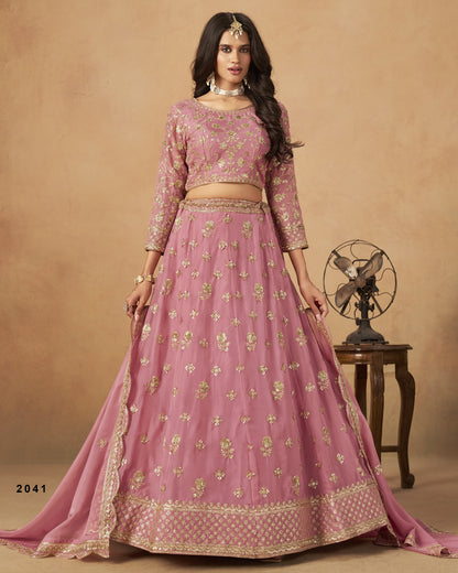 Pink traditional outfit with gold patterns on a beige background