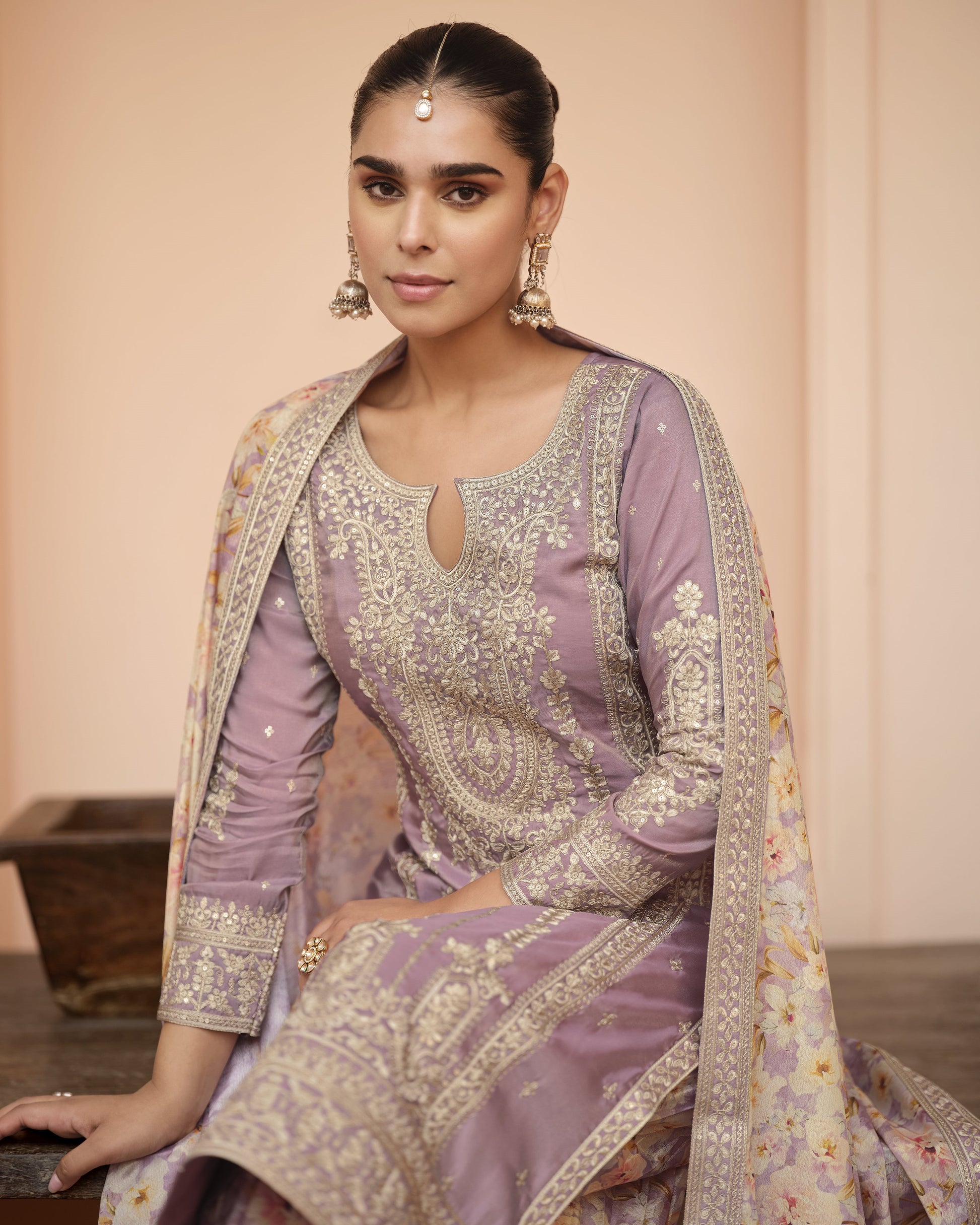 Woman wearing a traditional outfit with intricate patterns and embroidery.