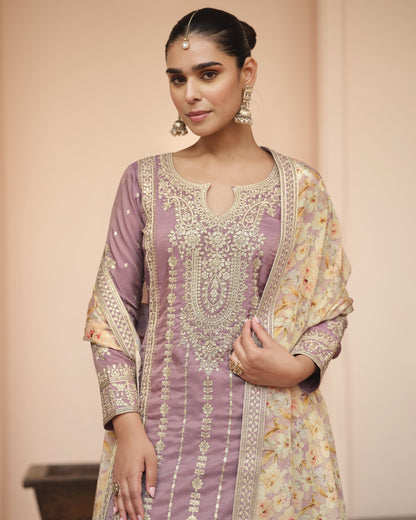 Woman wearing a traditional outfit with intricate patterns on a beige background