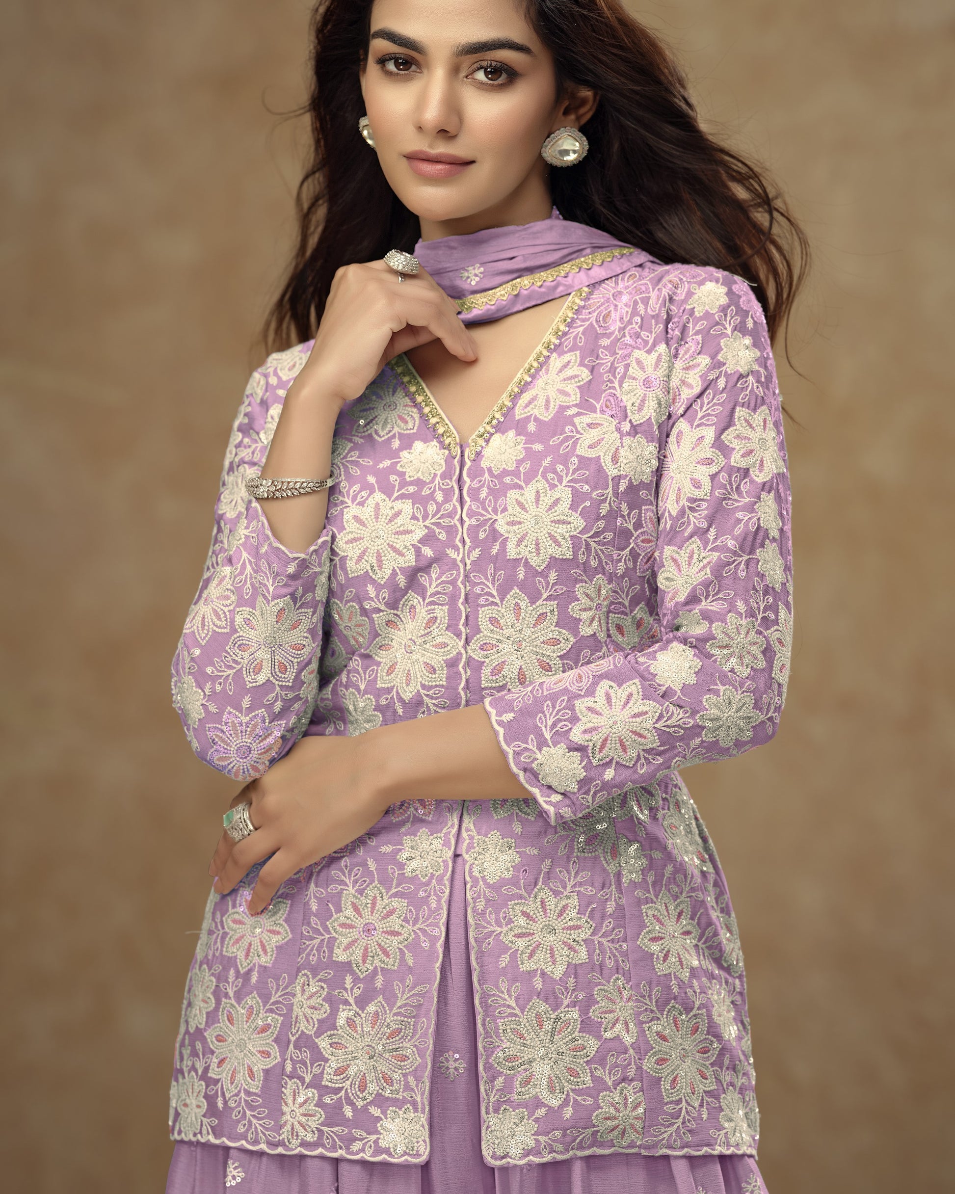 Woman wearing a purple floral outfit against a brown background