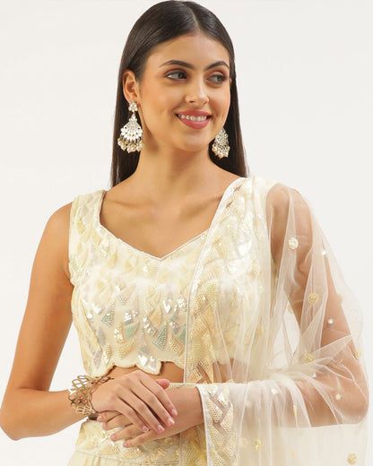 Woman wearing a cream-colored embroidered blouse with a sheer dupatta against a white background