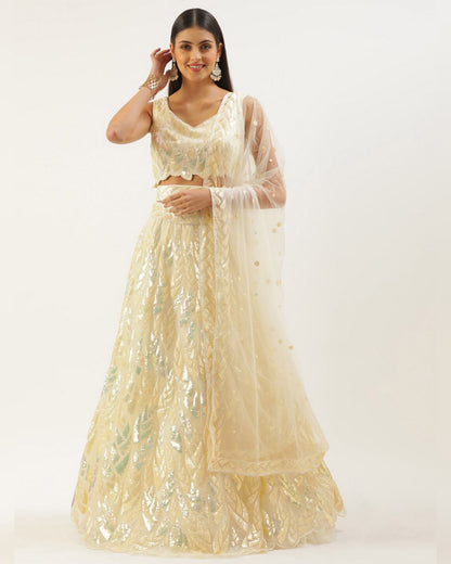 Woman wearing a beige embroidered lehenga with a matching dupatta on a white background
