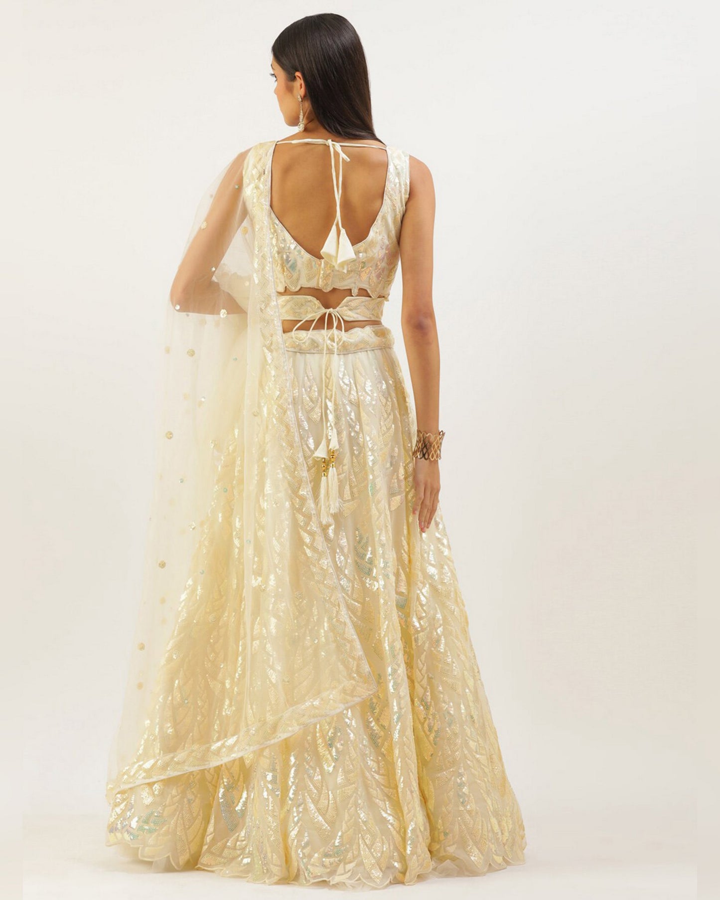 Woman wearing a gold evening gown with a white background