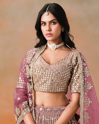 Woman wearing a traditional outfit with intricate designs on a beige background